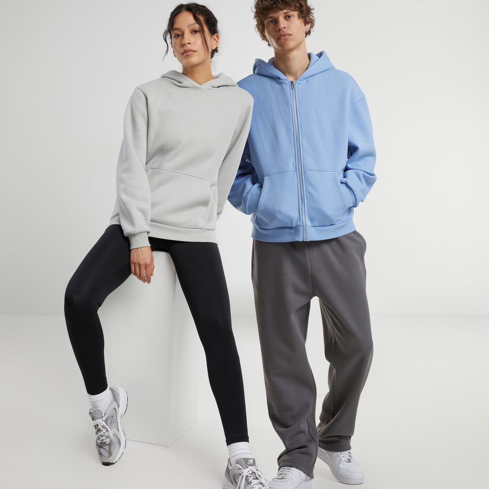 A woman in sportswear sat on a stool beside a man in sportswear 