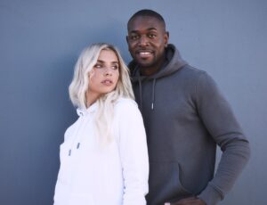 A man and woman stood together wearing hoodies