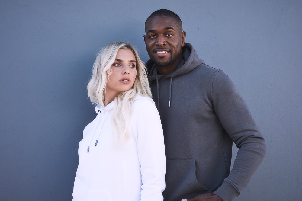 A man and woman stood together wearing hoodies