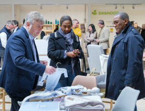 Buyers stood at a stand looking at clothing samples at BKS + FIMI