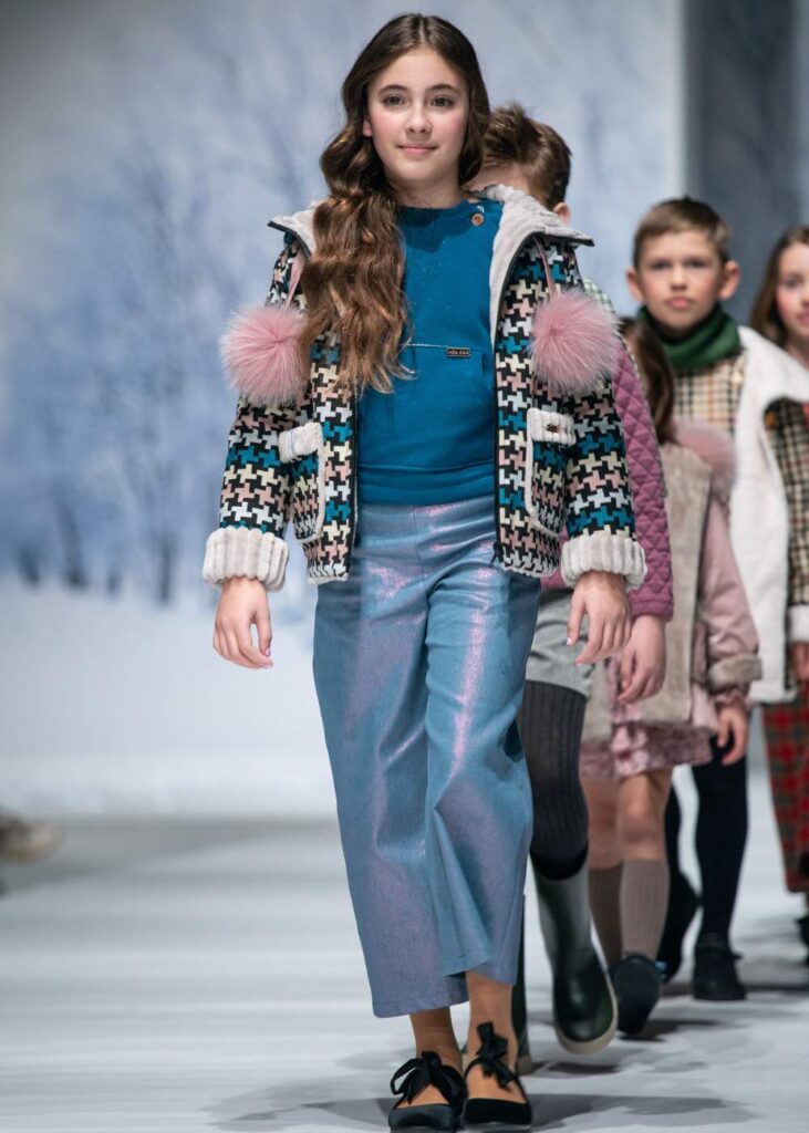 A row of children walking down a catwalk 