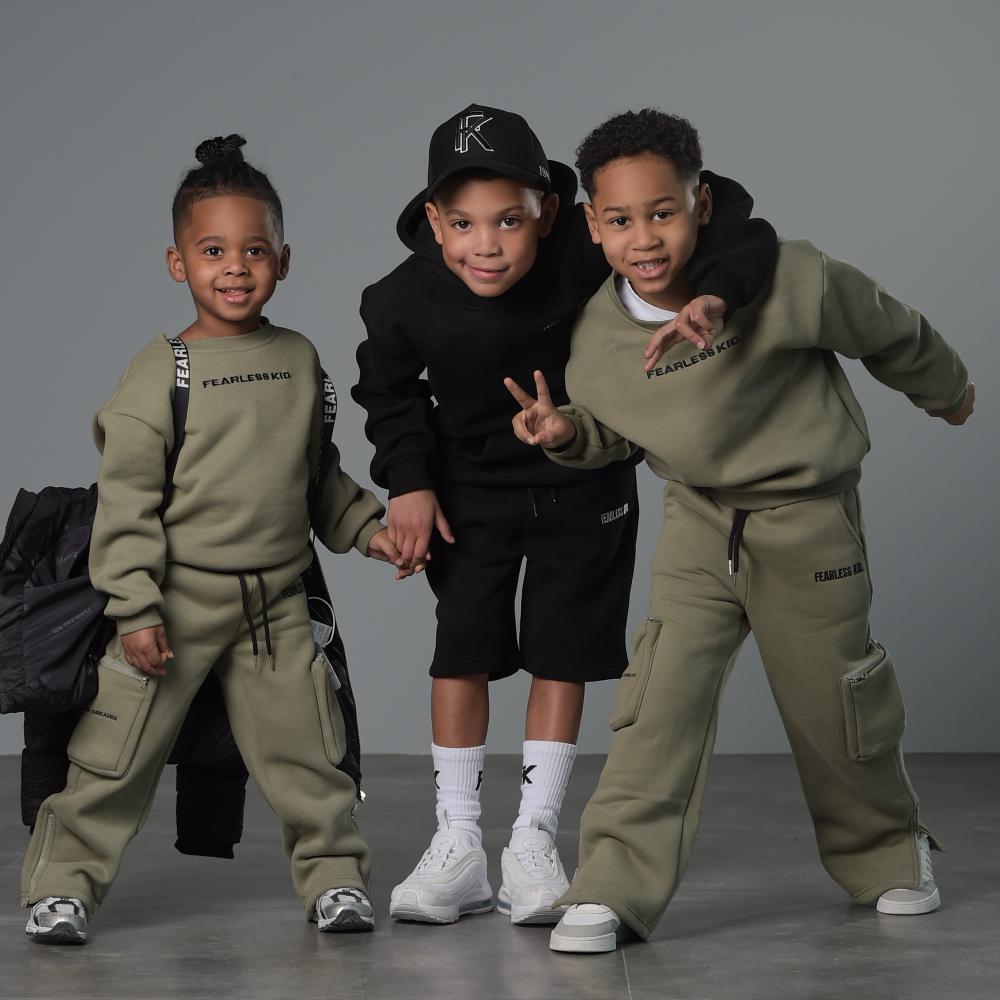 Three children holding hands in leisurewear 