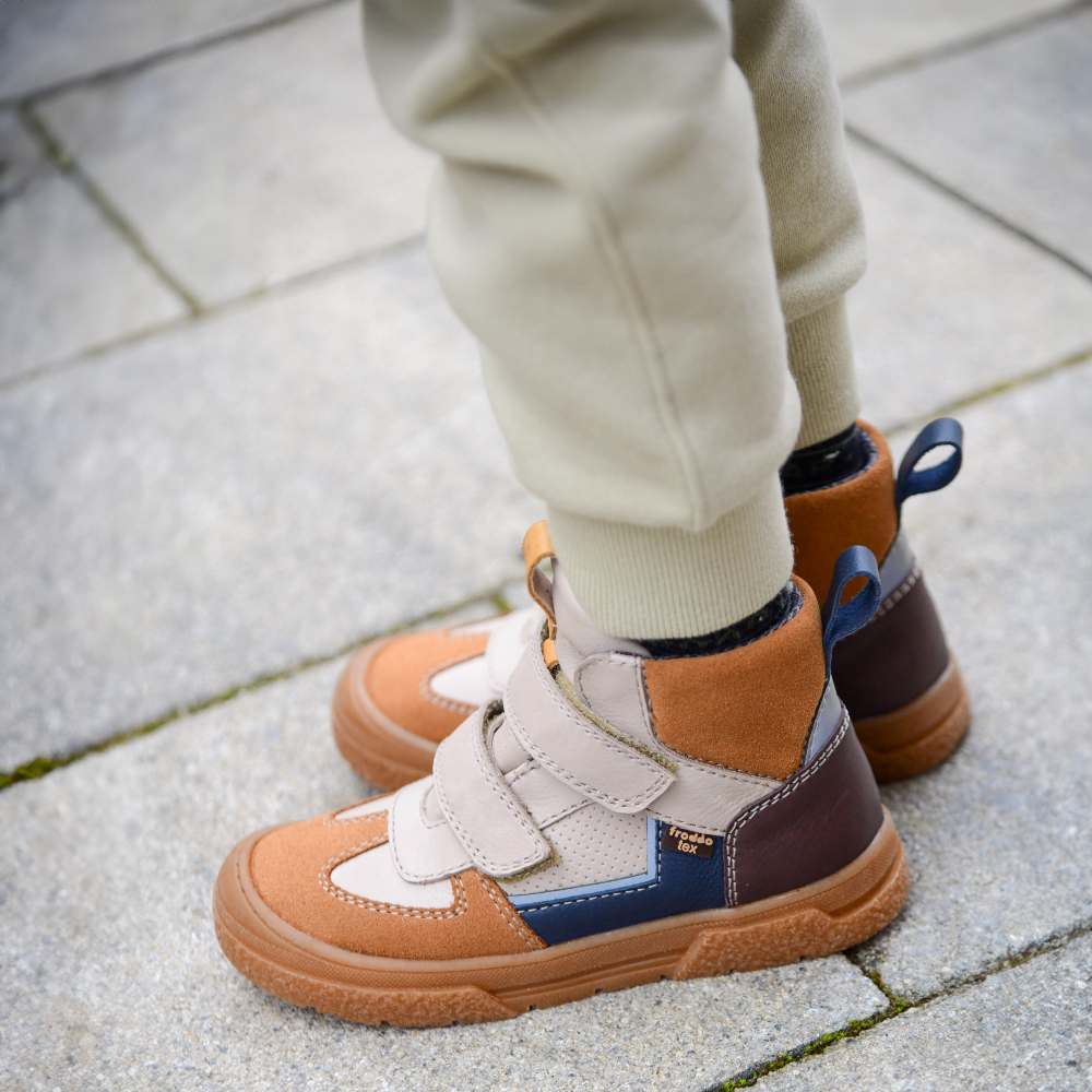 A child's legs and feet wearing hi-top trainers by Froddo