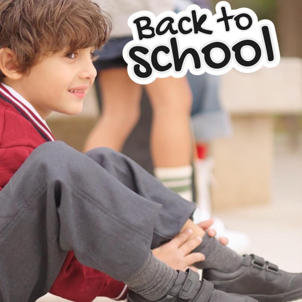 A child in school uniform sat on the floor outside 