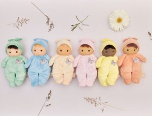 Soft baby dolls from the new Kaloo Tendre Bébé collection lined up amongst flowers