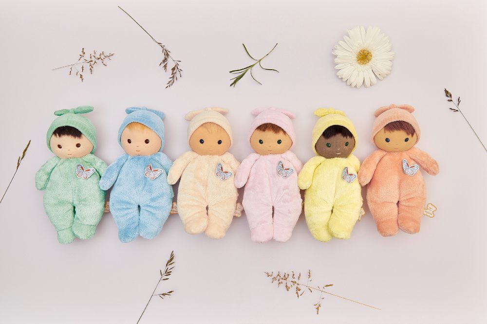 Soft baby dolls from the new Kaloo Tendre Bébé collection lined up amongst flowers