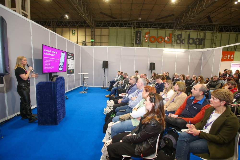 A speaker stood in front of an audience at Printwear & Promotion LIVE!