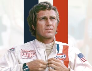 Steve McQueen pictured in a racing jacket in front of blue, white and red lines