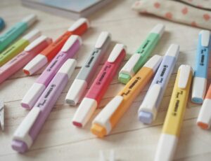 Pastel coloured highlighter pens by Stabilo laid out on a desk