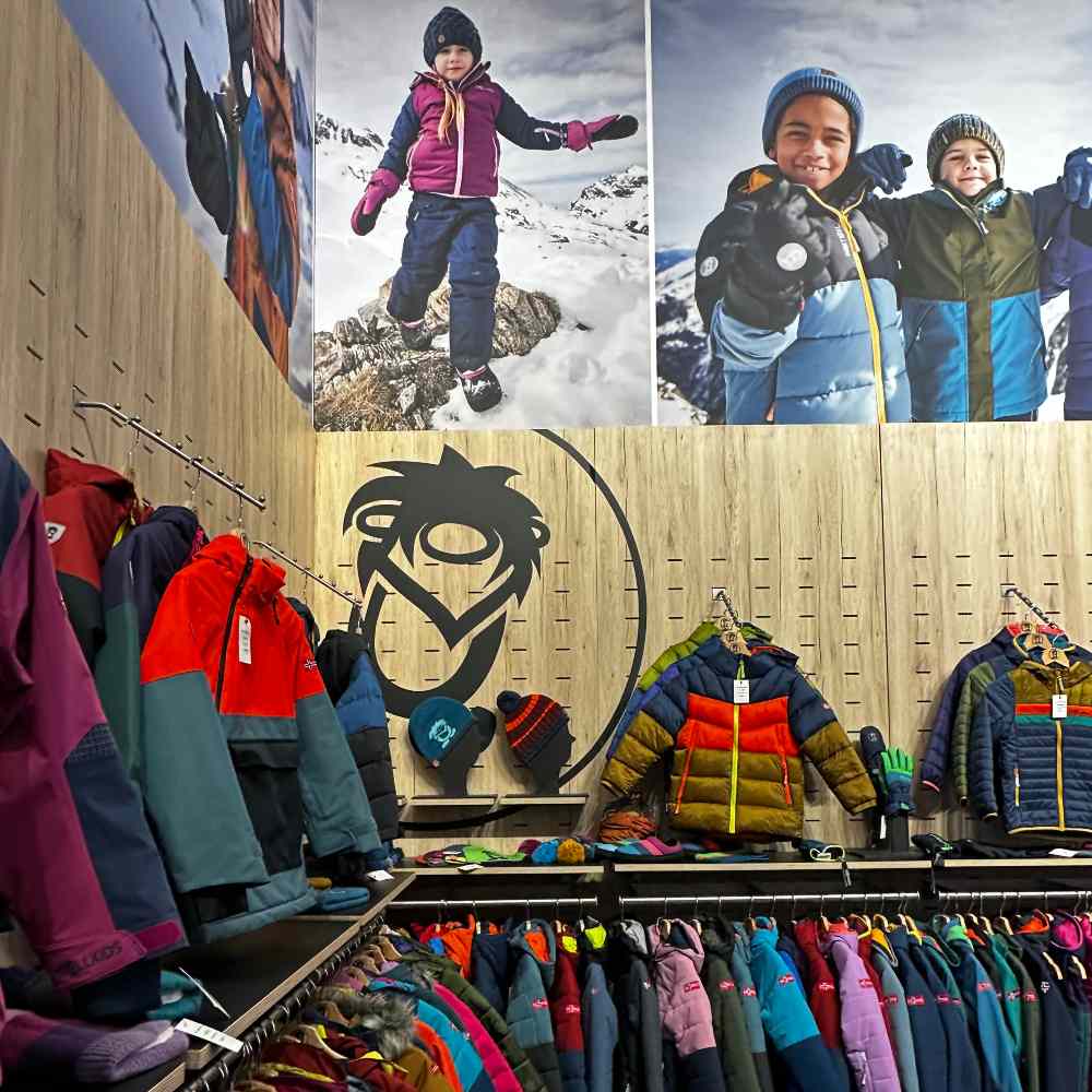 Children's winter clothing and outerwear displayed on a trade show stand at ISPO Munich 