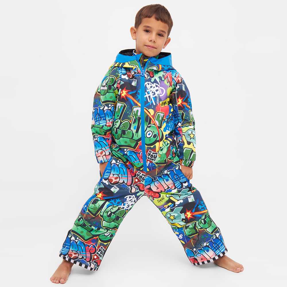 A child stood in a brightly coloured graffiti print snowsuit