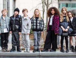 A group of children stood outside in a line on a wall