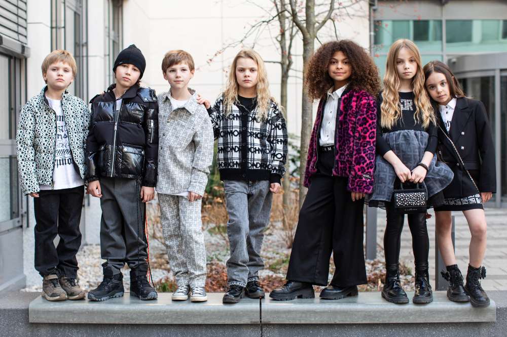 A group of children stood outside in a line on a wall