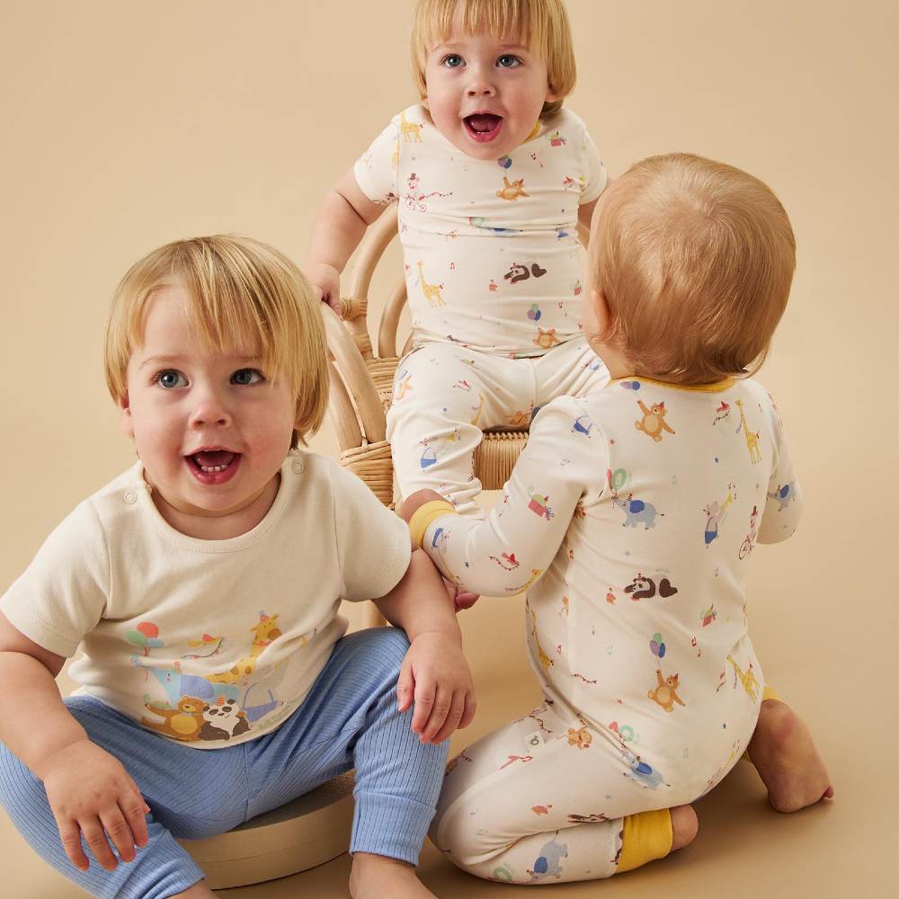 Three young children sat together wearing outfits from the Party Animals Collection 