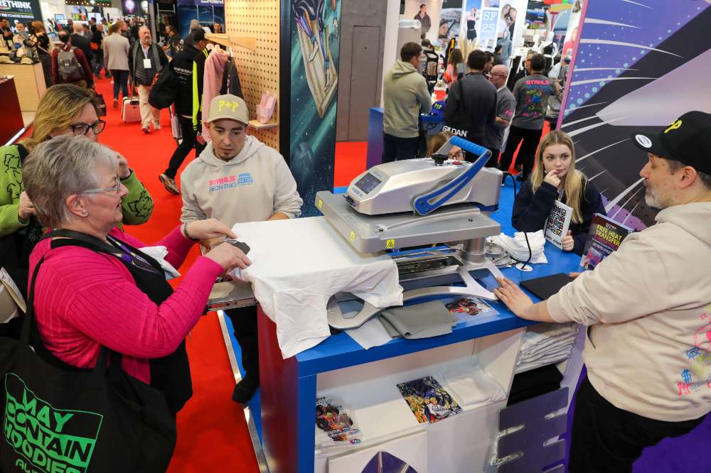 People watching a printer demonstration at Printwear & Promotion LIVE! 2025 