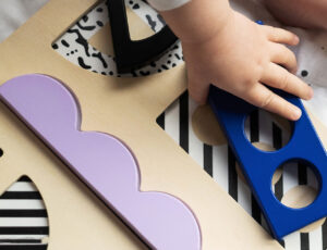 A young child playing with a puzzle board