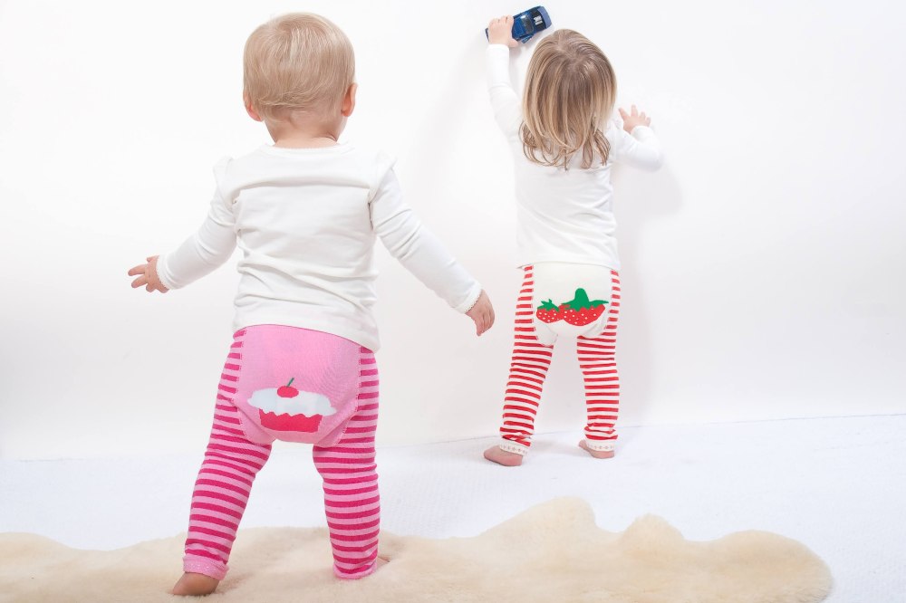 The back of two young children wearing knitted leggings with motifs on the bottoms by Blade & Rose 