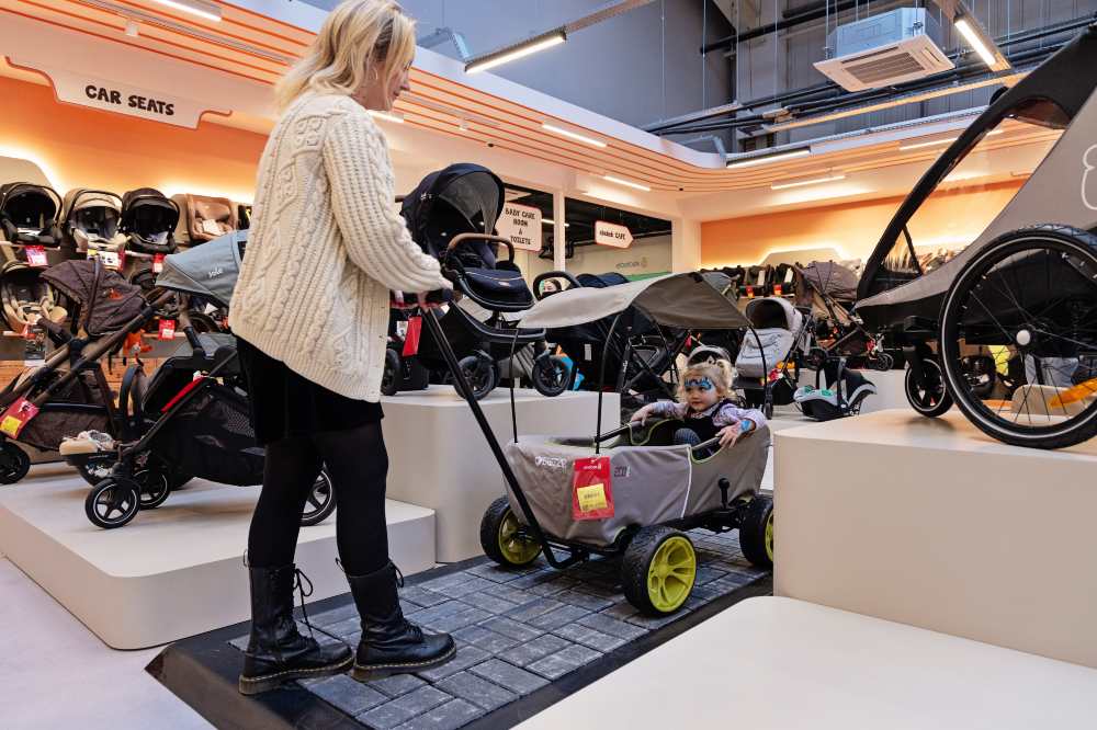A woman testing a child's pushchair in an Ebebek store 