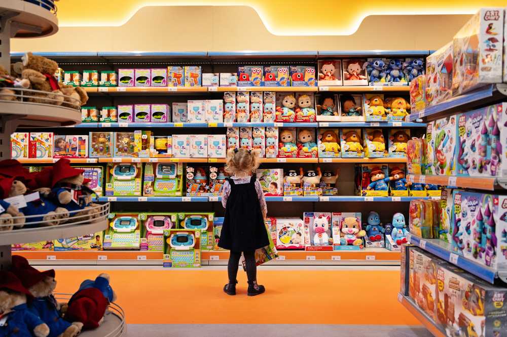 A young girl stood inside an Ebebek store looking at shelves full of toys 