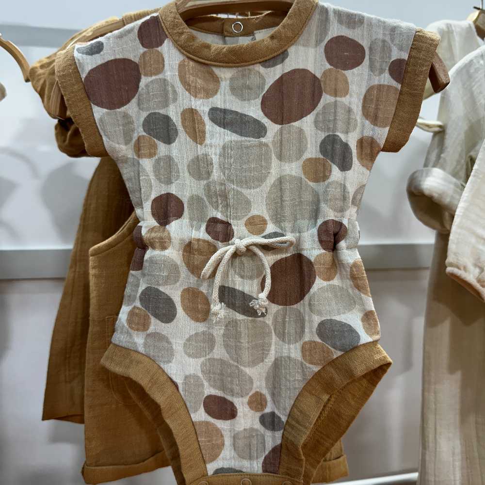 A baby's bodysuit hung on a clothes rail 