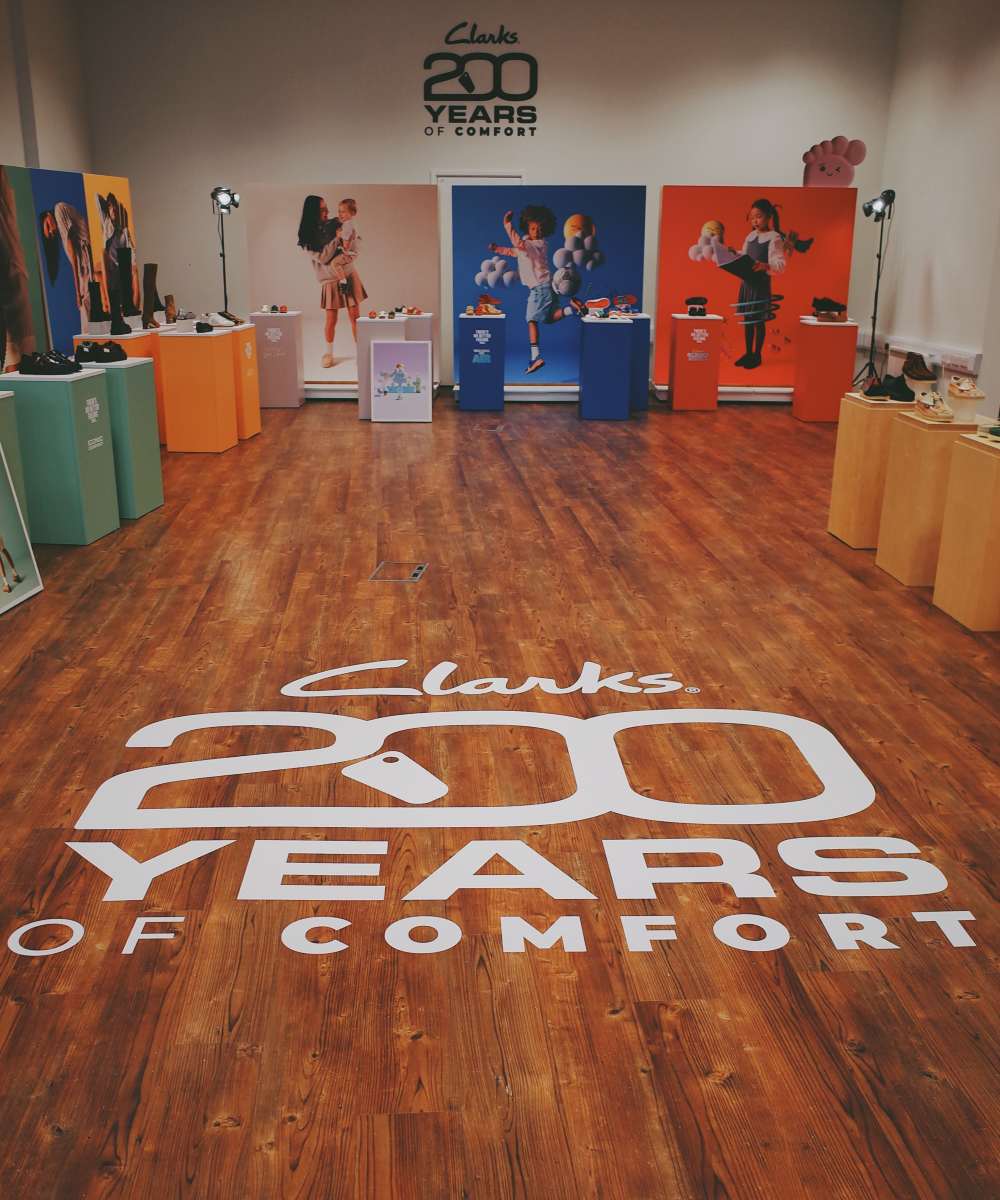 A room displaying Clarks kids shoes with Clark 200 years of comfort written on the floor 