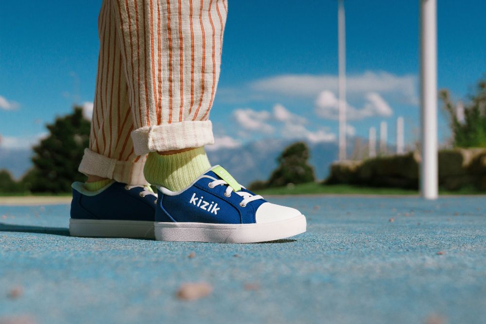 A child's feet shown outside wearing blue shoes