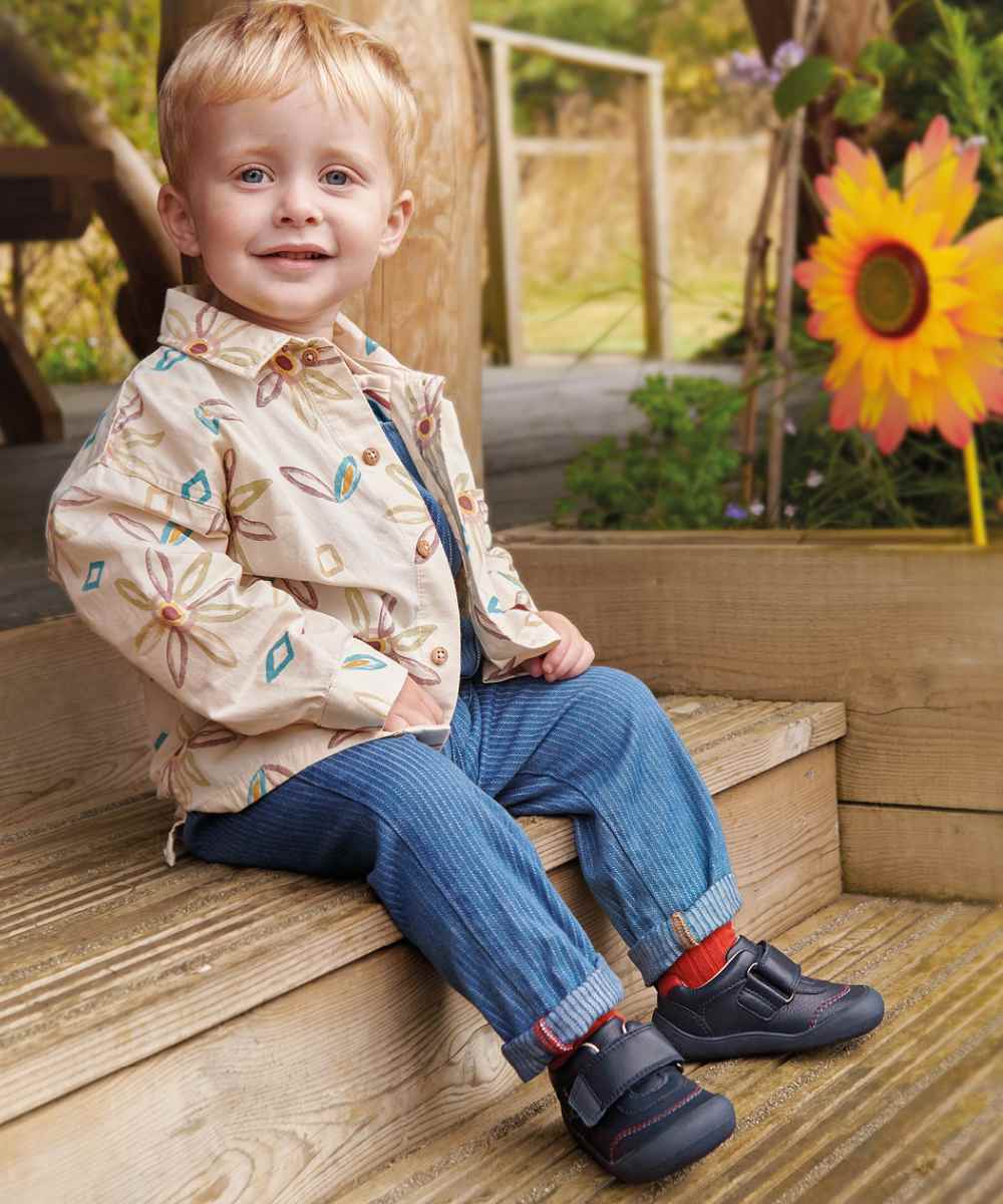 A young boy sat outside on a step 