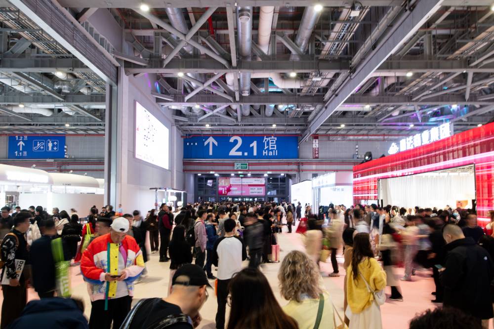 Lots of people stood in an exhibition hall at the CHIC trade fair