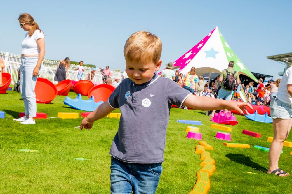 A child outside playing at Totfest alongside the Edx Education play tent