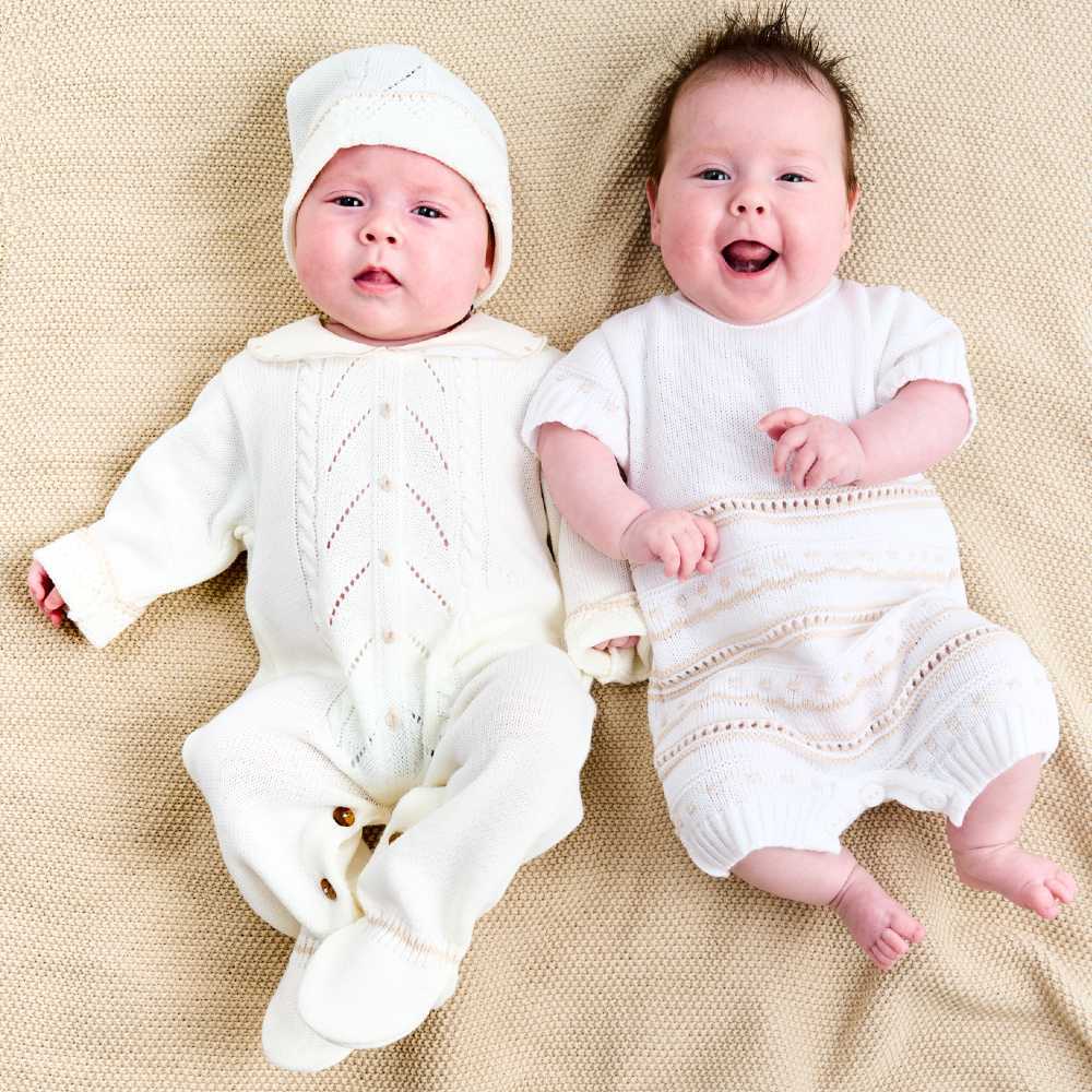 Two babies lying on a blanket