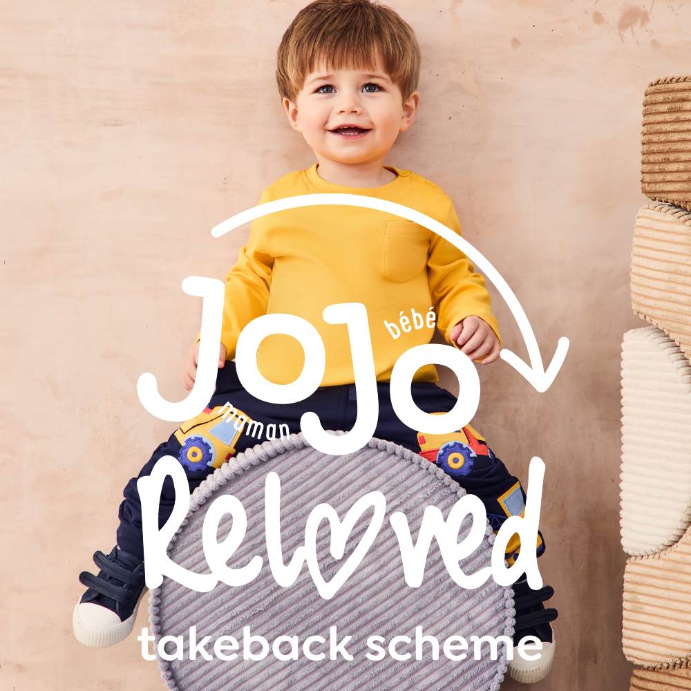 A child sat on a cushion against the Jojo Reloved logo 