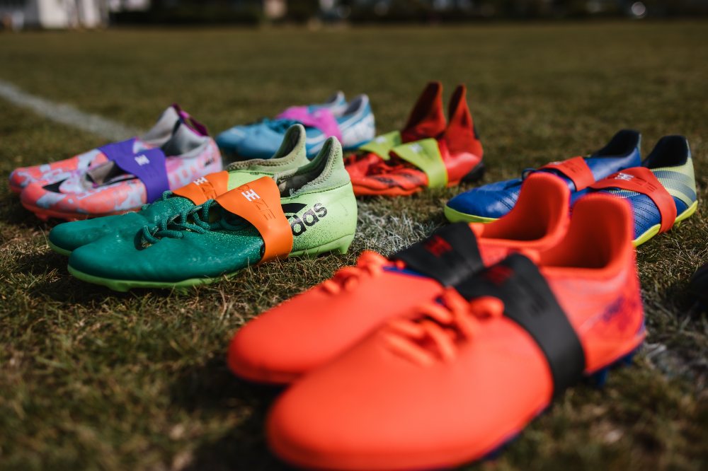 Brightly coloured trainers on a sports field with Laceeze on them