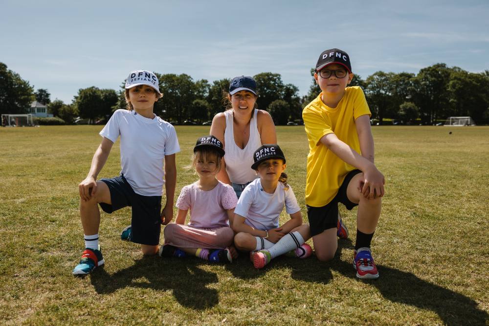 A woman with a group of children on a sports field