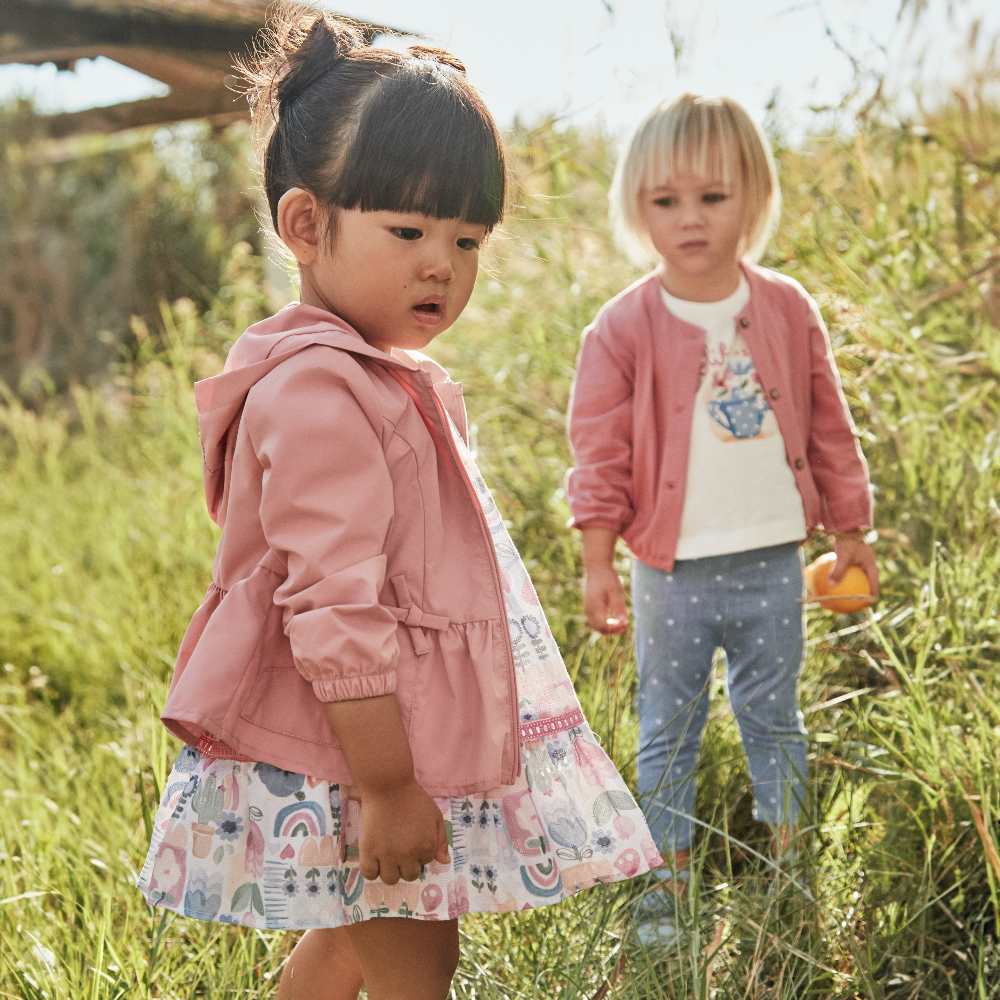 Two young children stood in a field 