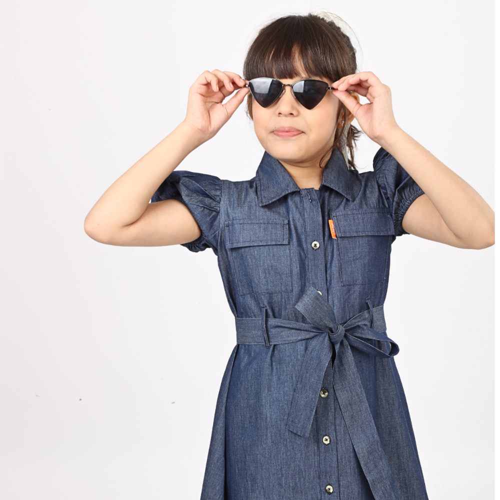 A girl in a denim dress and sunglasses 