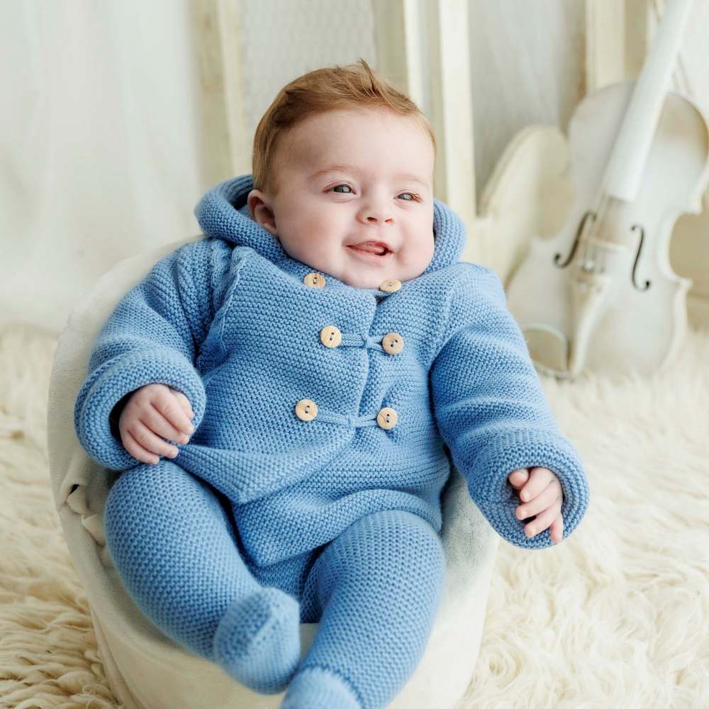 A baby wearing a knitted blue outfit 