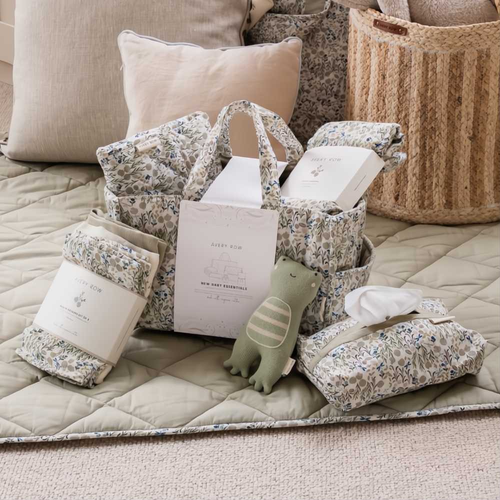 The New Baby Essentials baby Gift Set by Avery Row displayed on the floor in a room 