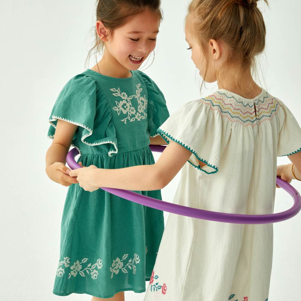 Two girls in simmer dress stood in a purple hoola-hoop 