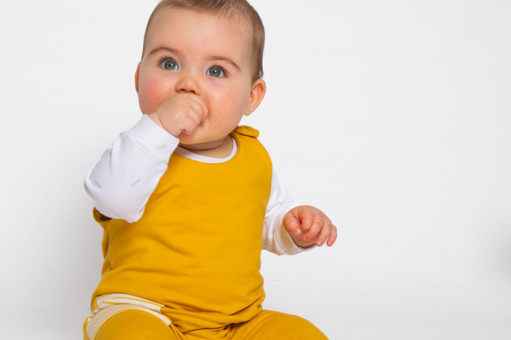 A baby sat on the floor wearing a yellow and white outfit by #SBS winner Pickle
