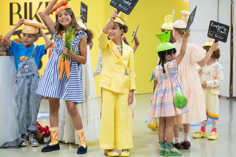 A group of children holder signs up at the Pirouette Parade at Pitti Bimbo 101