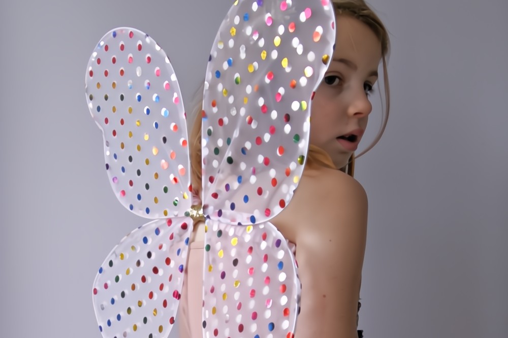 A girl in a set of fairy wings with different coloured metallic spots from the Rockahula Dress Up Collection