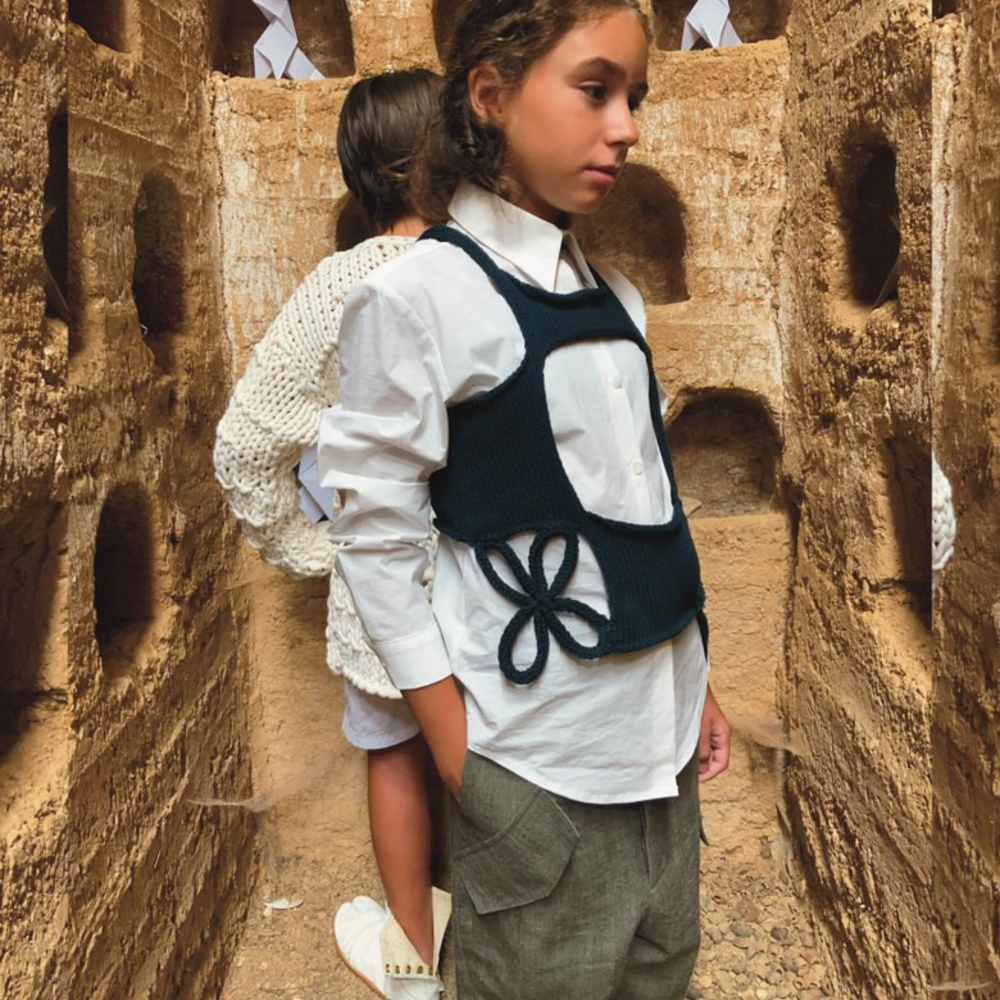 Two children stood in a wooden box with large holes in it