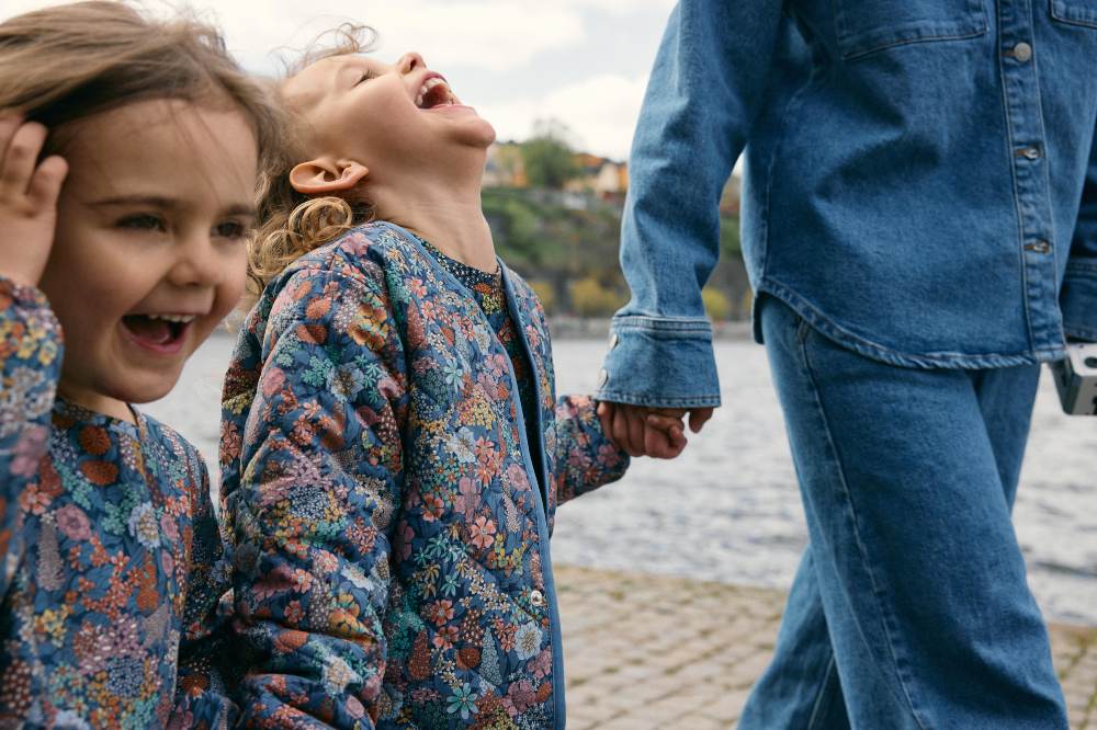Two children walking outside with an adult wearing Liberty Fabric jackets by PO.P