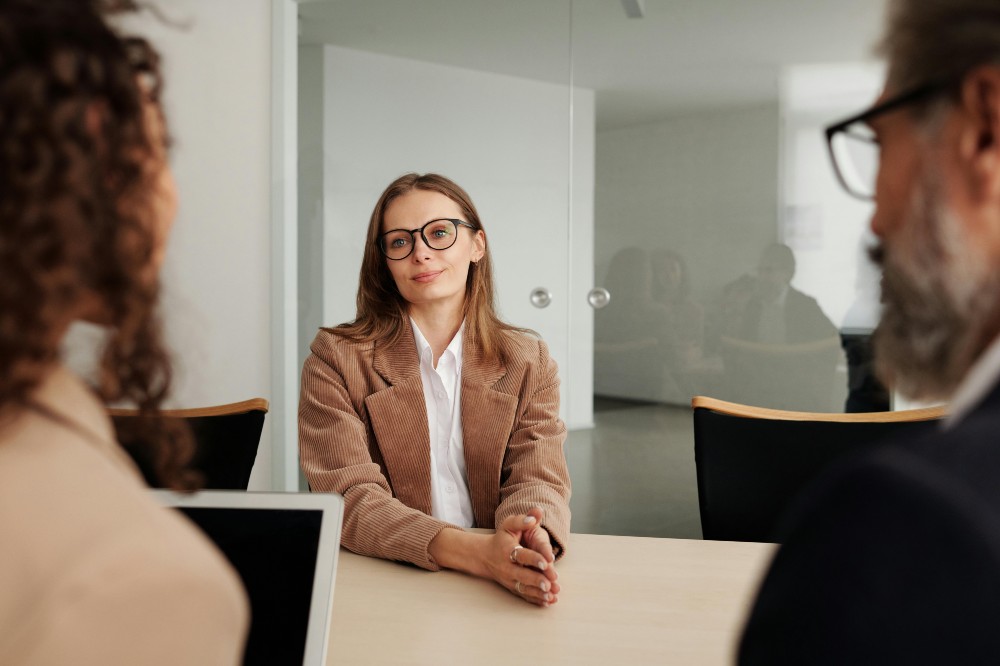 A woman sat at a desk in an office having a job interview