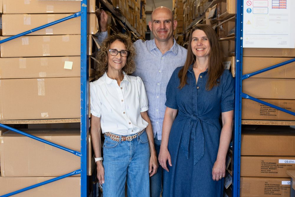 Three people stood in a warehouse