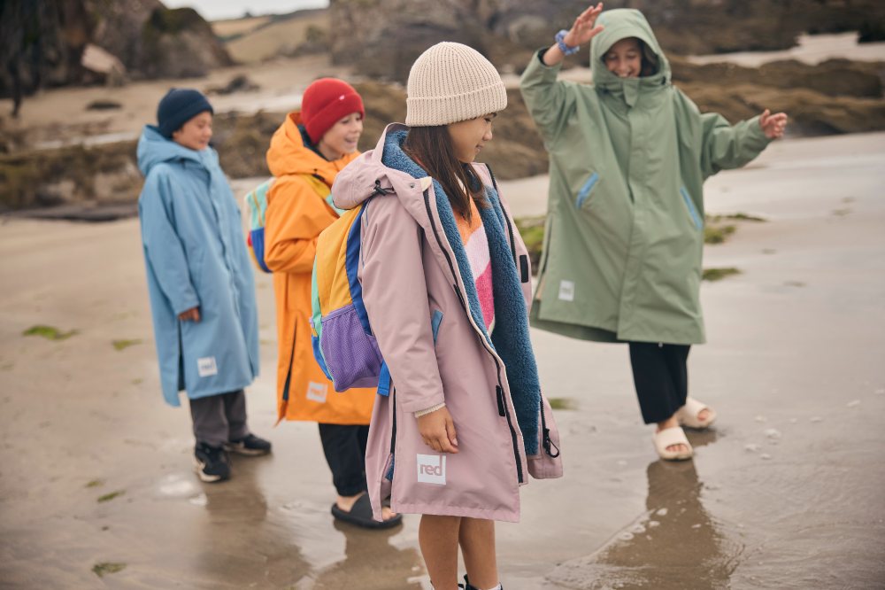 Children stood on a beach wearing Evo Pro Change Robes by Red Equipment
