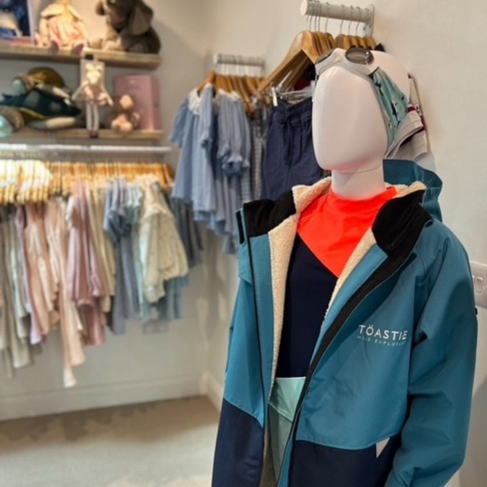 Children's clothes displayed on rails and a mannequin in Dottie & Oscar Children's Boutique 