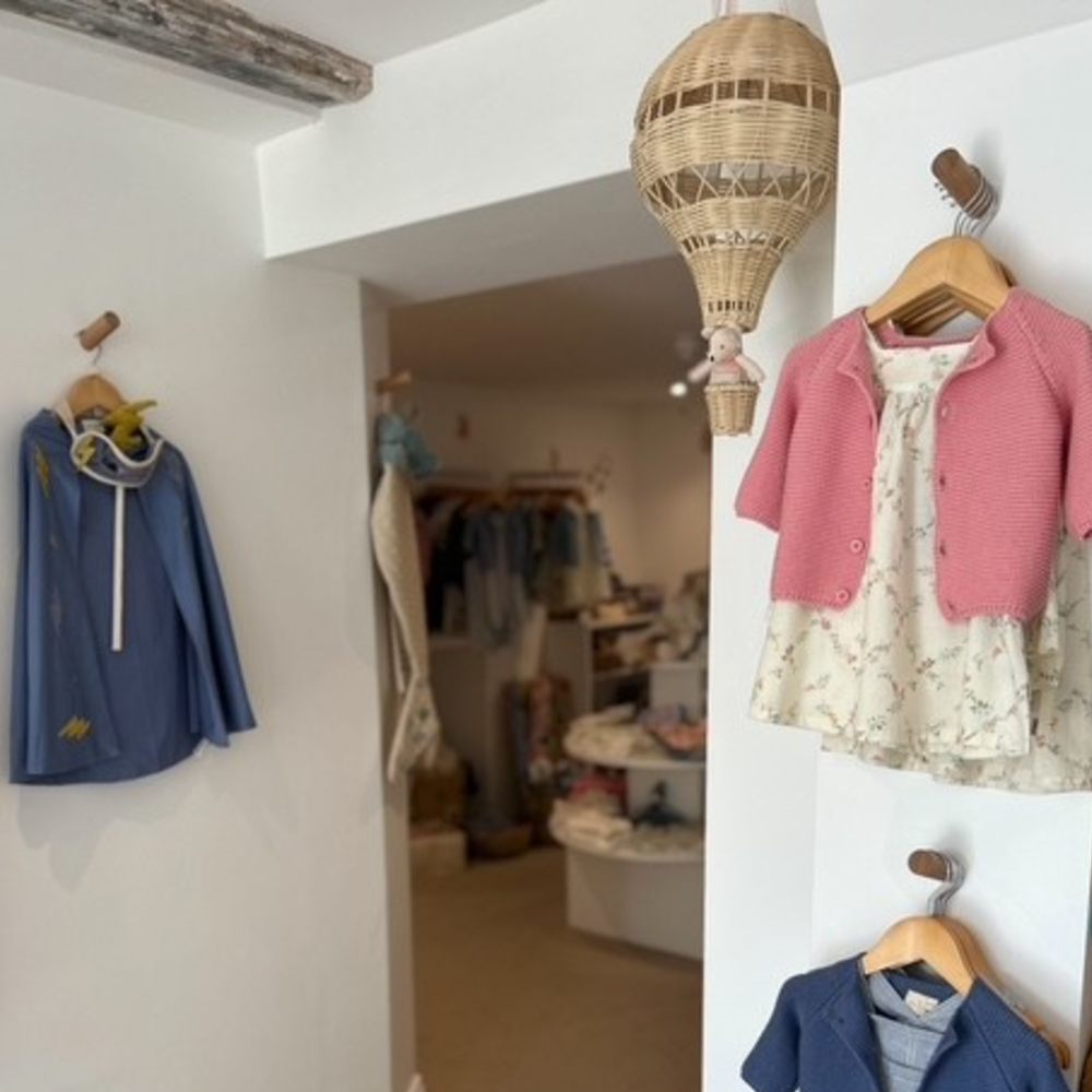 Children's outfits displayed on the wall in Dottie & Oscar Children's Boutique 