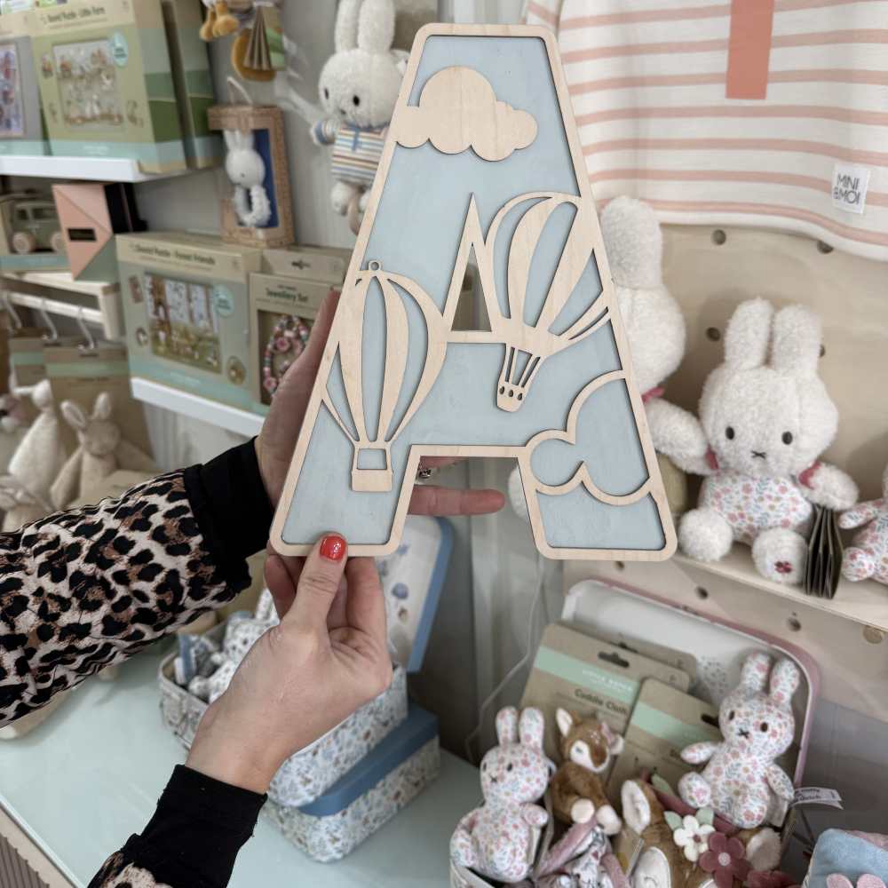 Someone holding up a large decorative letter A in the Nellie's Keepsake Co. shop 
