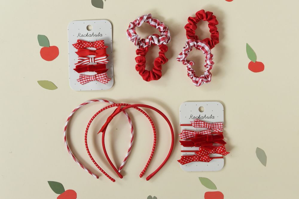 Children's red school hair accessories by Rockahula Kids displayed on a background of red apples